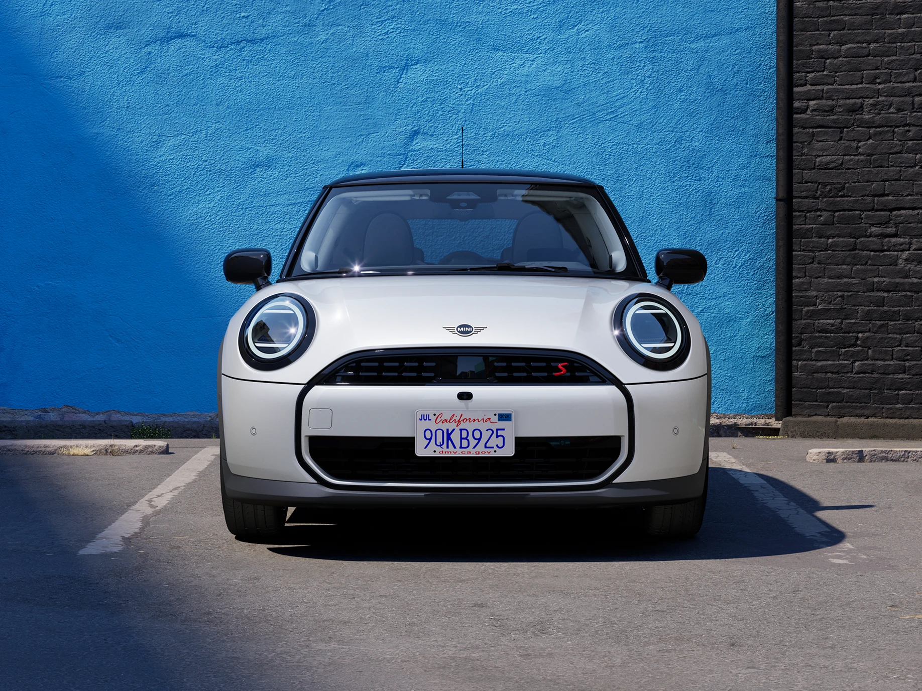 Vista frontale della MINI Cooper in Nanuq White con tetto nero parcheggiata.