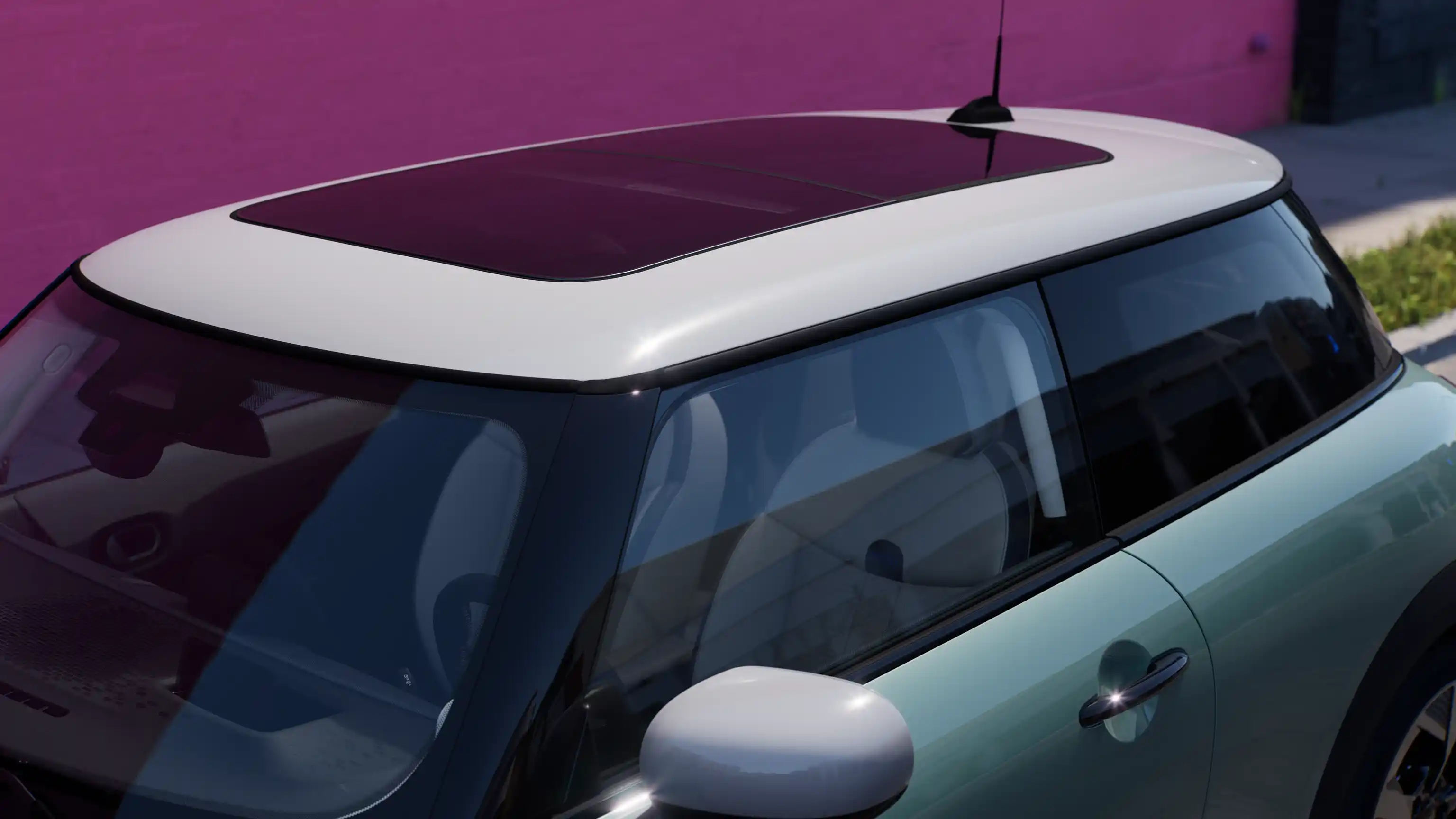 Vista dall’alto della MINI Cooper nella colorazione Ocean Wave Green con tetto a contrasto e ampio tetto in vetro.