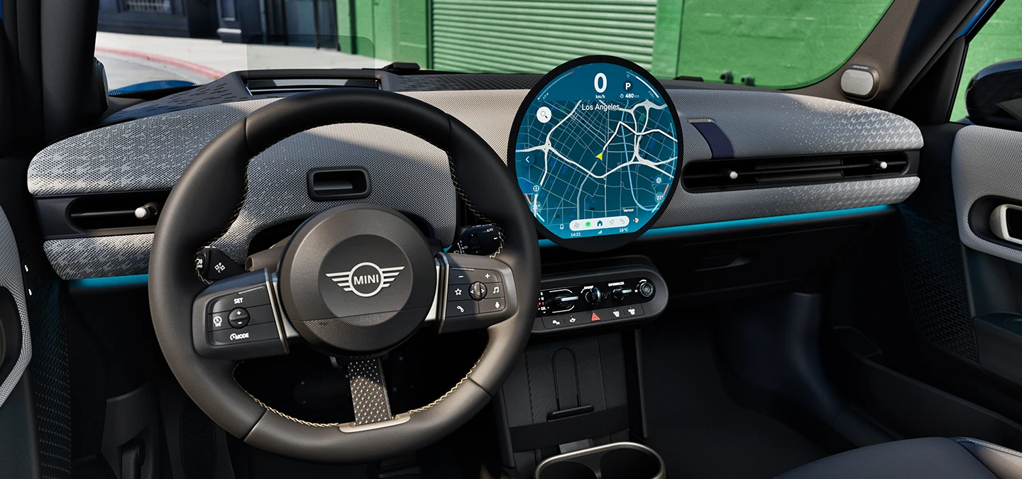 Vista interna della MINI Cooper 5 porte con focus sul volante, la plancia e l'unità di interazione.