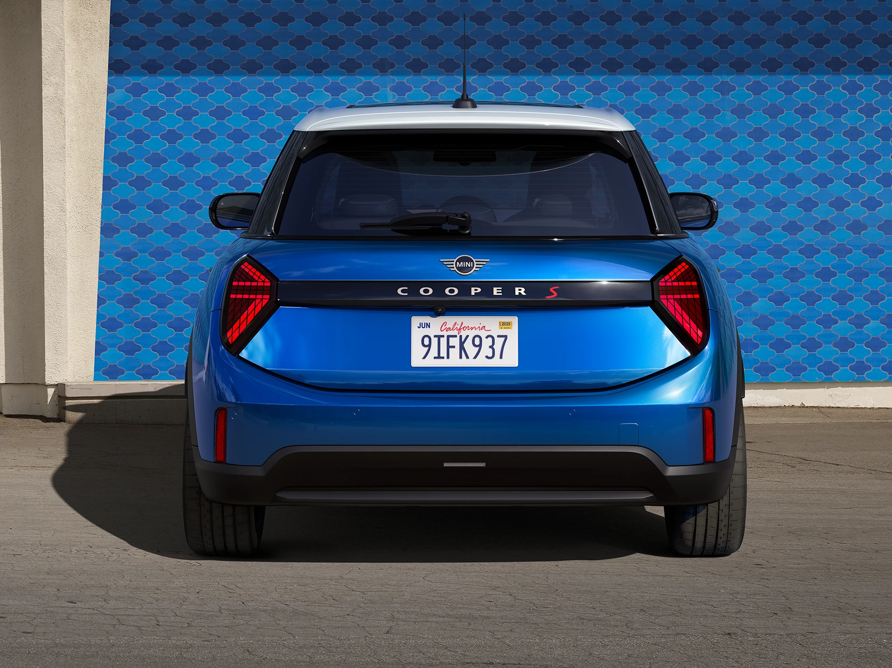Vista posteriore della MINI Cooper 5 porte in Icy Sunshine Blue con tetto Multitone Blue.