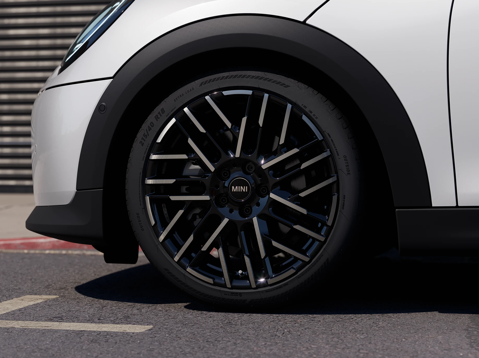 Primo piano della MINI Cooper 5 porte in Nanuq White con cerchi Night Flash Spoke bicolore.