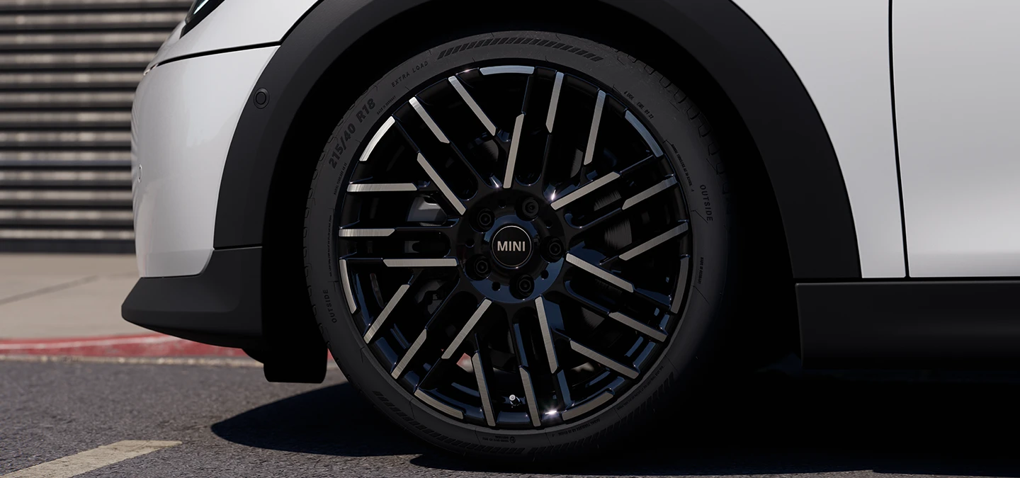 Primo piano della MINI Cooper 5 porte in Nanuq White con cerchi Night Flash Spoke bicolore.