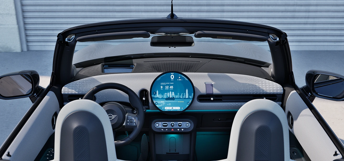 Vista posteriore degli interni della MINI Cooper cabrio con focus sulla plancia e sull'unità di interazione.