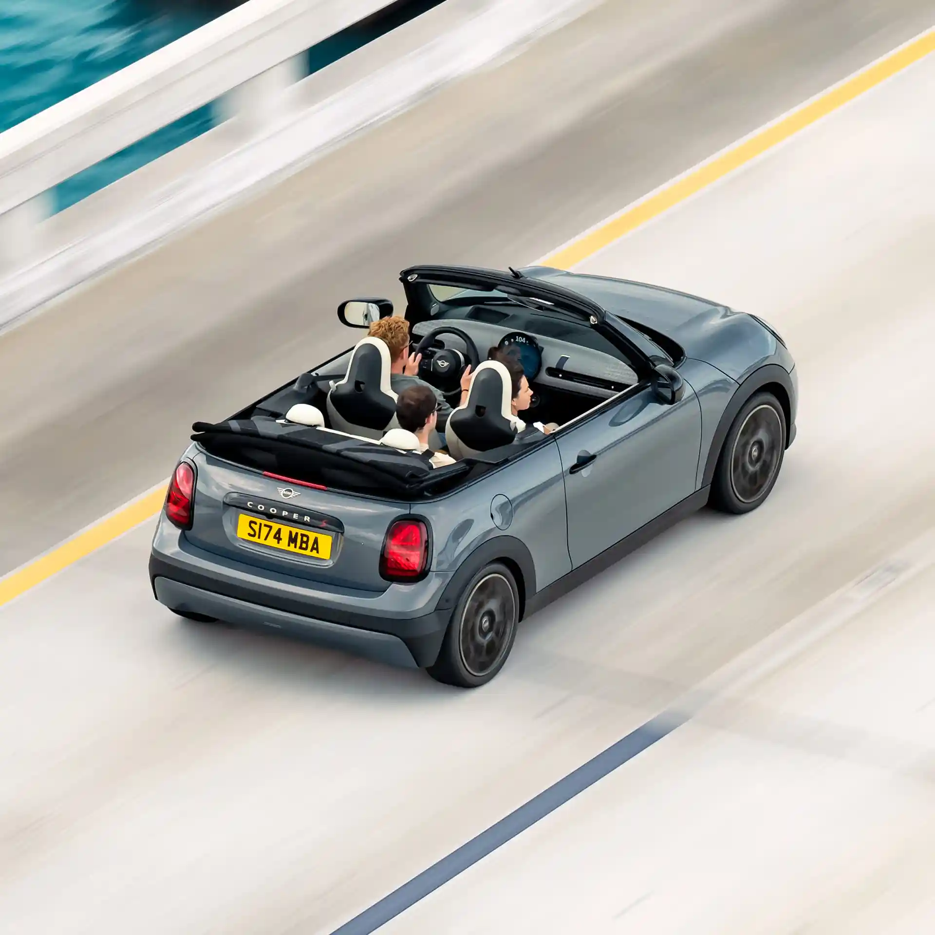 Vista posteriore dall’alto di una MINI Cooper Cabrio in movimento su strada