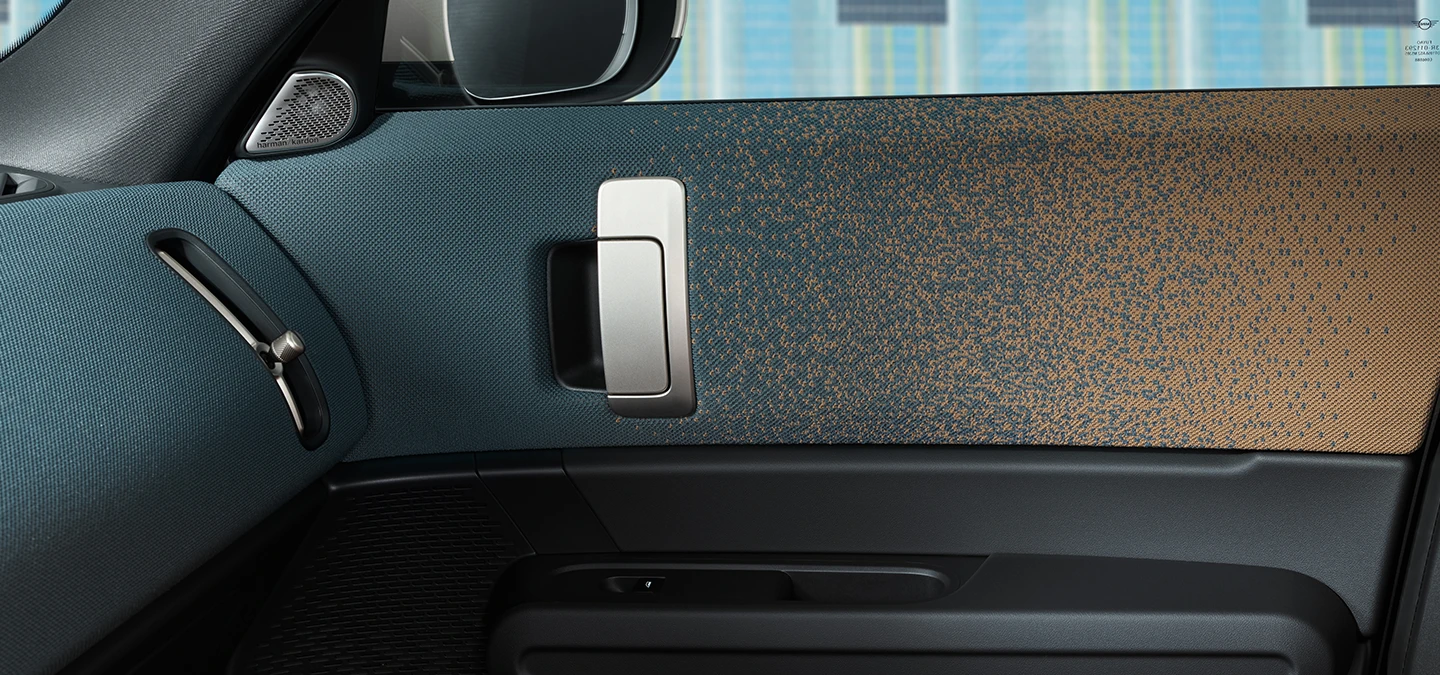 Vista ravvicinata del design degli interni di MINI Countryman 100% elettrica, con focus su portiera e plancia.