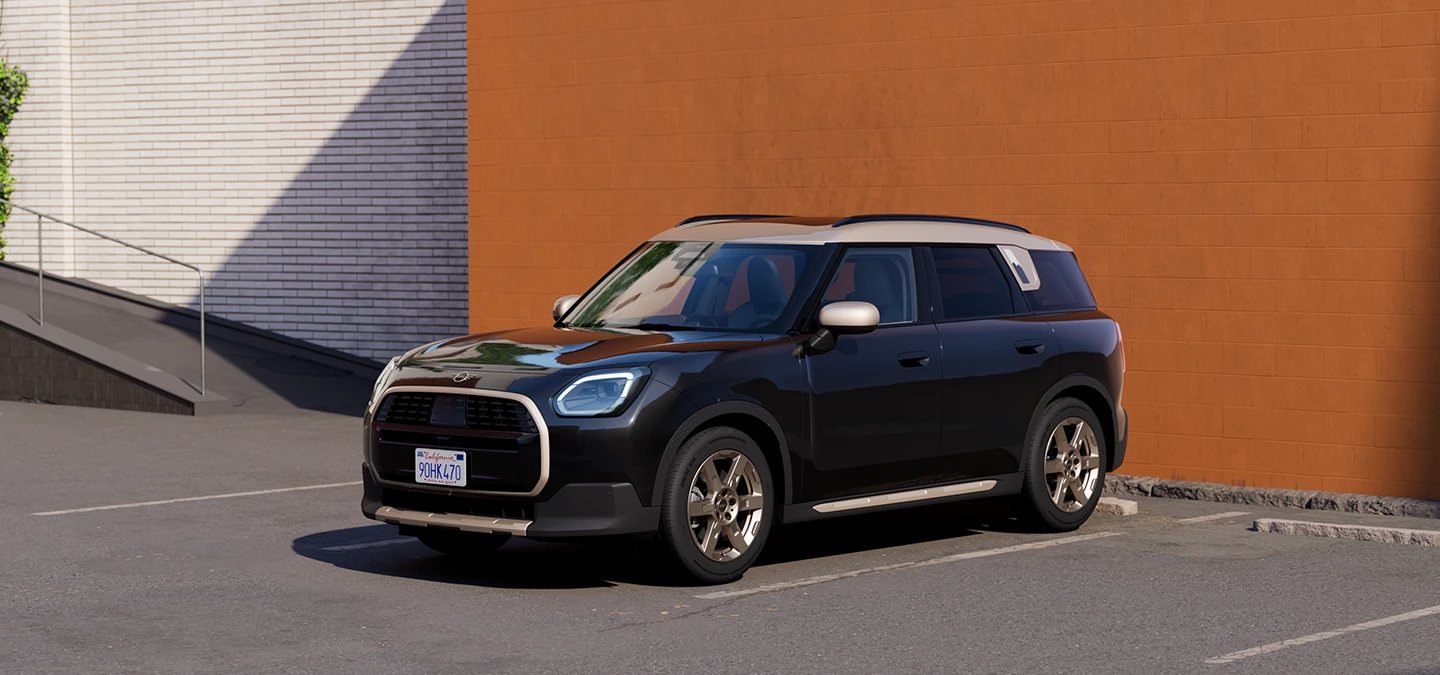 Vista frontale laterale della MINI Countryman in Midnight Black e con tetto Vibrant Silver, parcheggiata.