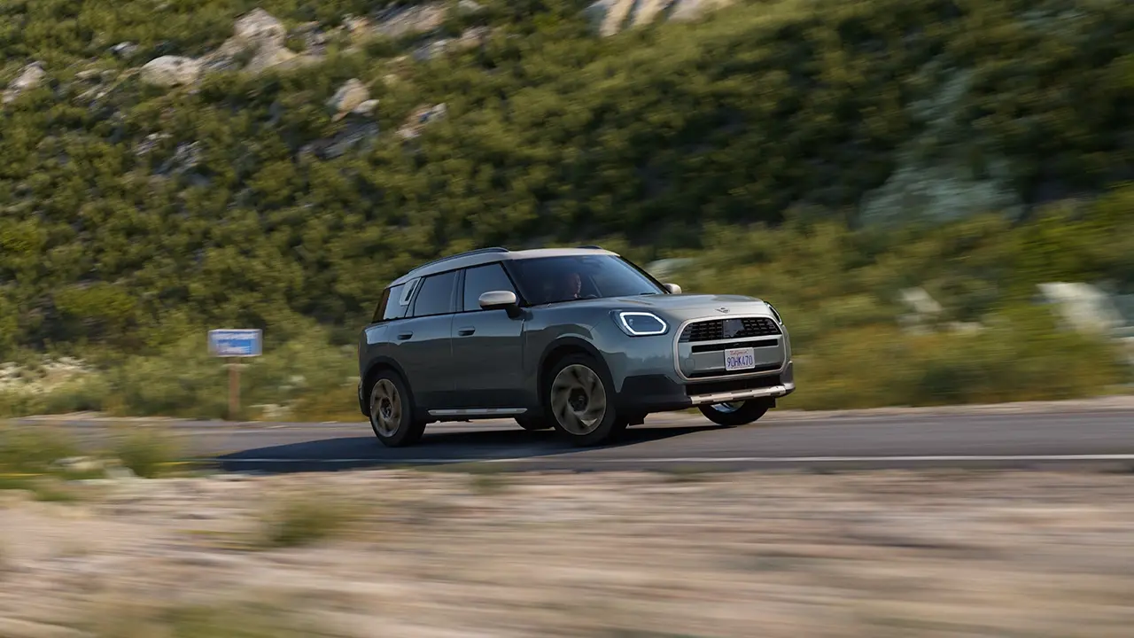Vista della MINI Countryman in Smokey Green e stile Favoured durante la guida fuoristrada