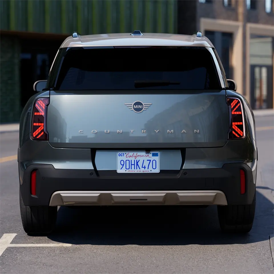 Vista posteriore di una MINI Countryman in Smokey Green con tetto in Vibrant Silver in fase di parcheggio