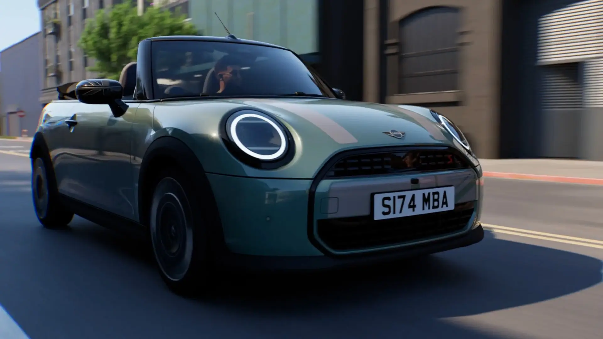 MINI Cabrio in Ocean Wave Green con decalcomanie bianche MINI Heritage e calotte degli specchietti Union Jack mentre attraversa la città.