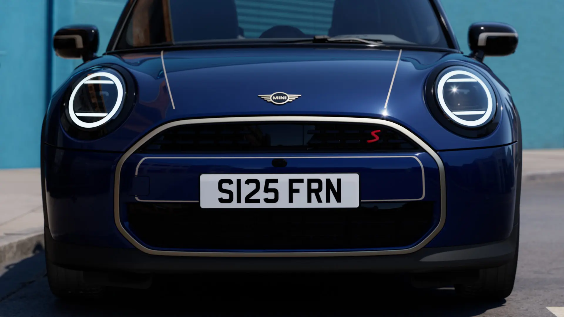 Vista frontale della MINI Cabrio in blu con decalcomanie per il cofano anteriore MINI Favoured di colore argento.