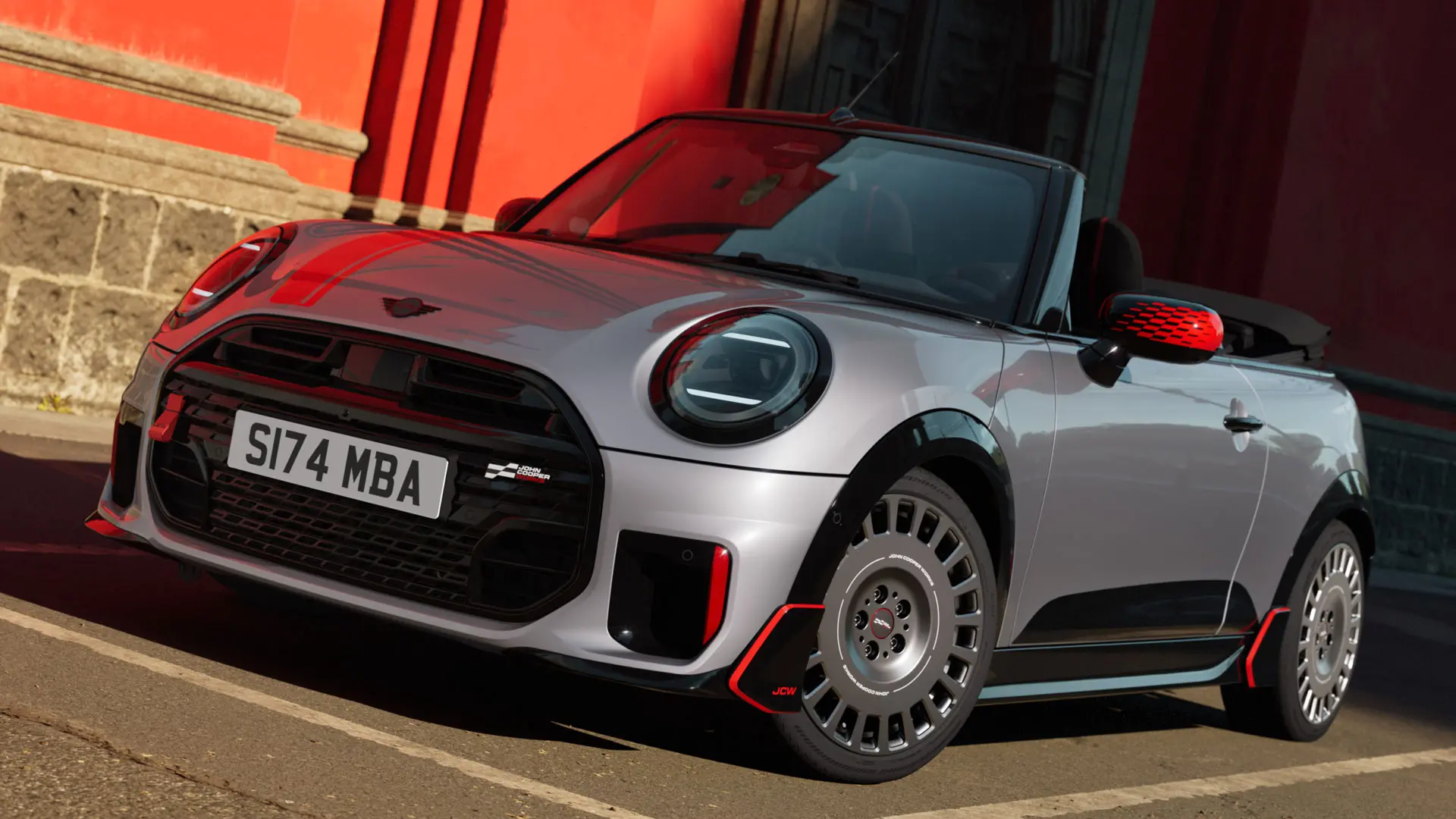 MINI Cabrio di colore argento con elementi stilistici sportivi JCW, tra cui calotte degli specchietti MINI JCW, strisce sportive e winglet.