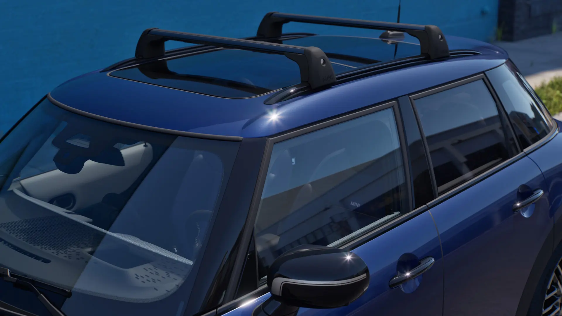 Dettaglio frontale e laterale di una MINI Aceman in Indigo Sunset Blue dotata di portapacchi MINI. 