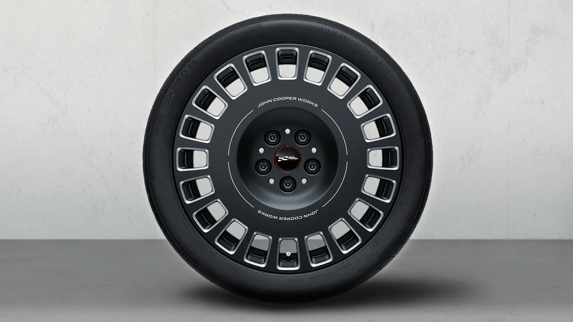 Cerchio JCW Rallye Spoke 992 da 18'', con logo JCW e design bicolore in Frozen Midnight Grey con finitura fresata lucida.
