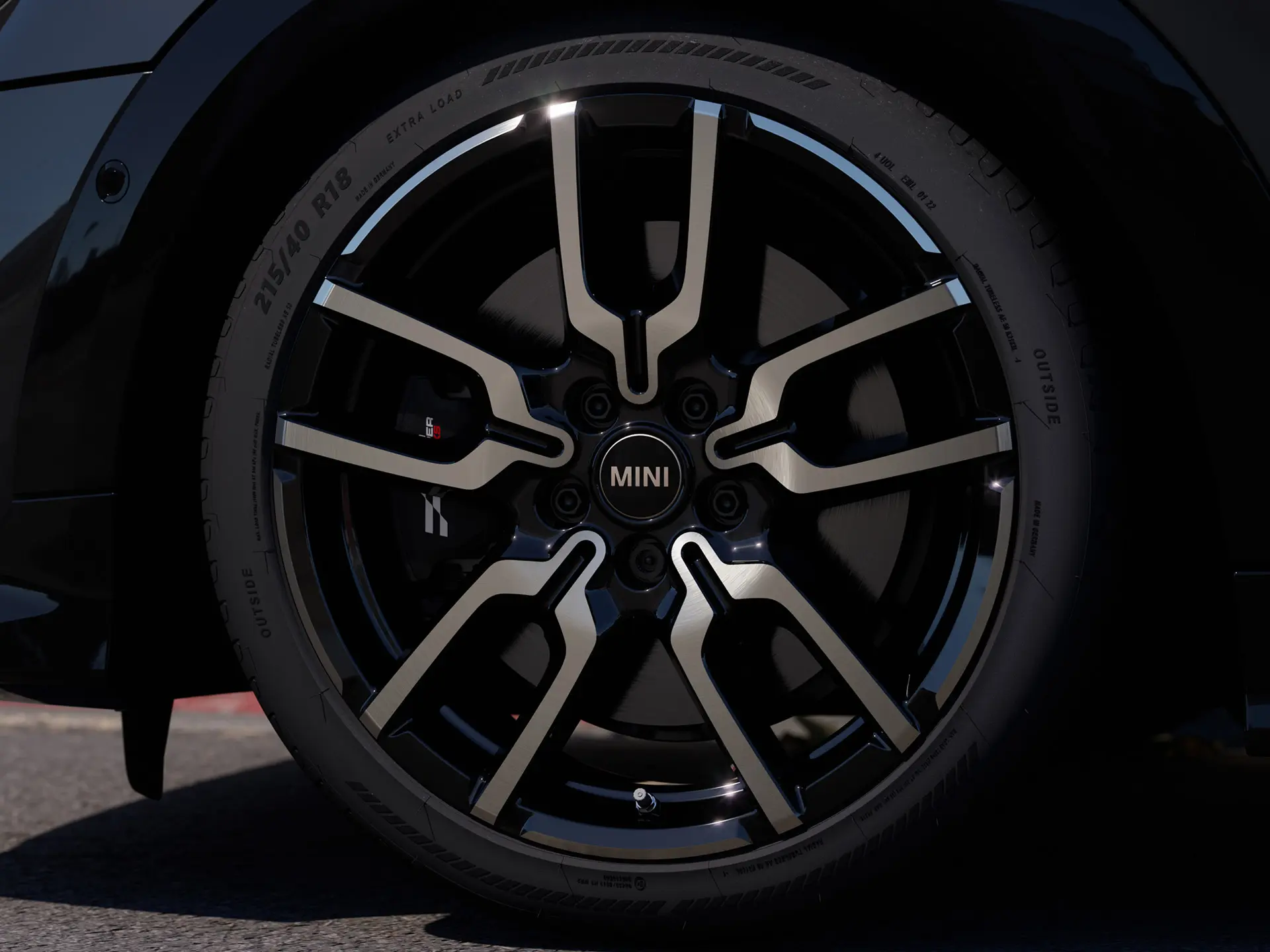 Immagine in primo piano del cerchio in lega JCW Lap Spoke che evidenzia il caratteristico design a razze aperte in finitura Jet Black.