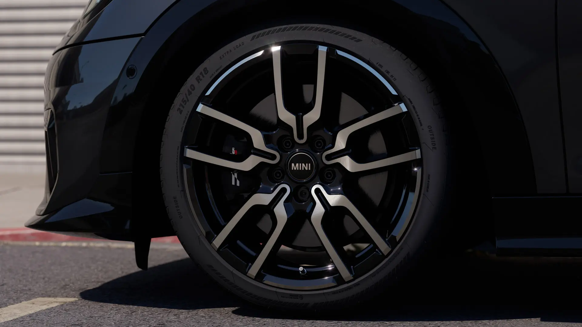 Immagine in primo piano del cerchio in lega JCW Lap Spoke che evidenzia il caratteristico design a razze aperte in finitura Jet Black.