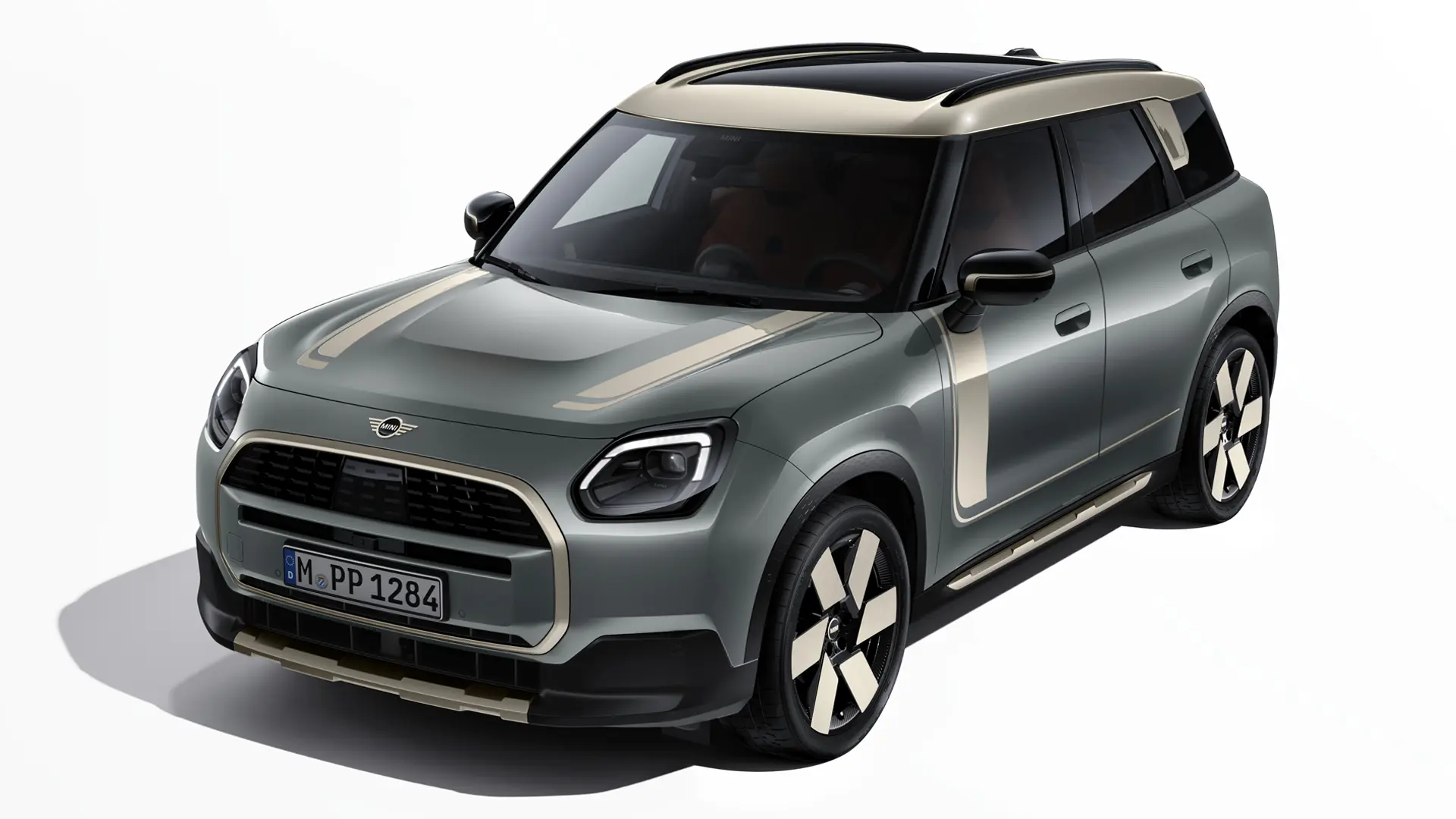 MINI Countryman Electric in Smokey Green con adesivi MINI Favoured in Vibrant Silver, vista di tre quarti.