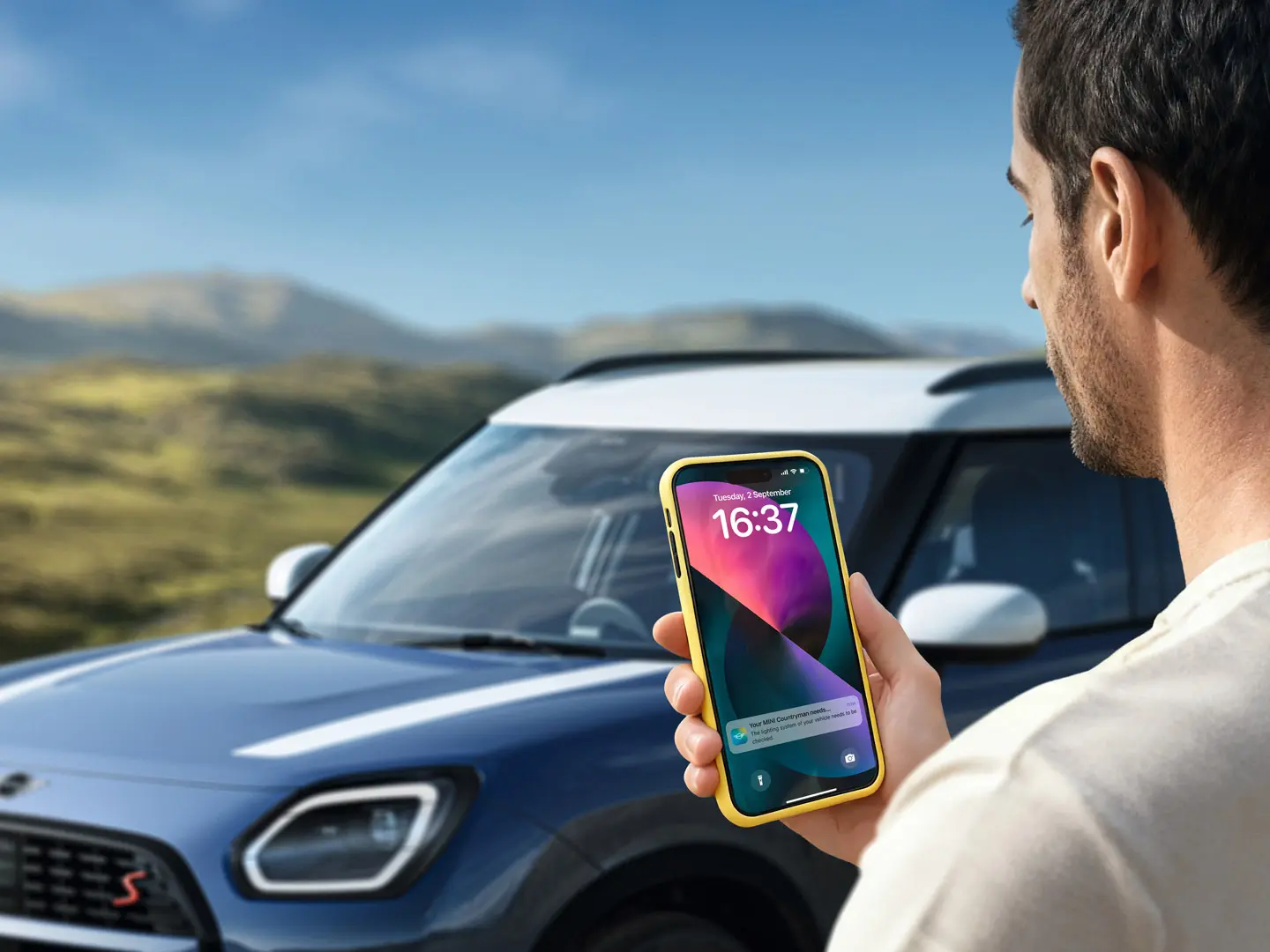 Un conducente MINI Countryman che utilizza la MINI App per contattare l’assistenza stradale MINI. 