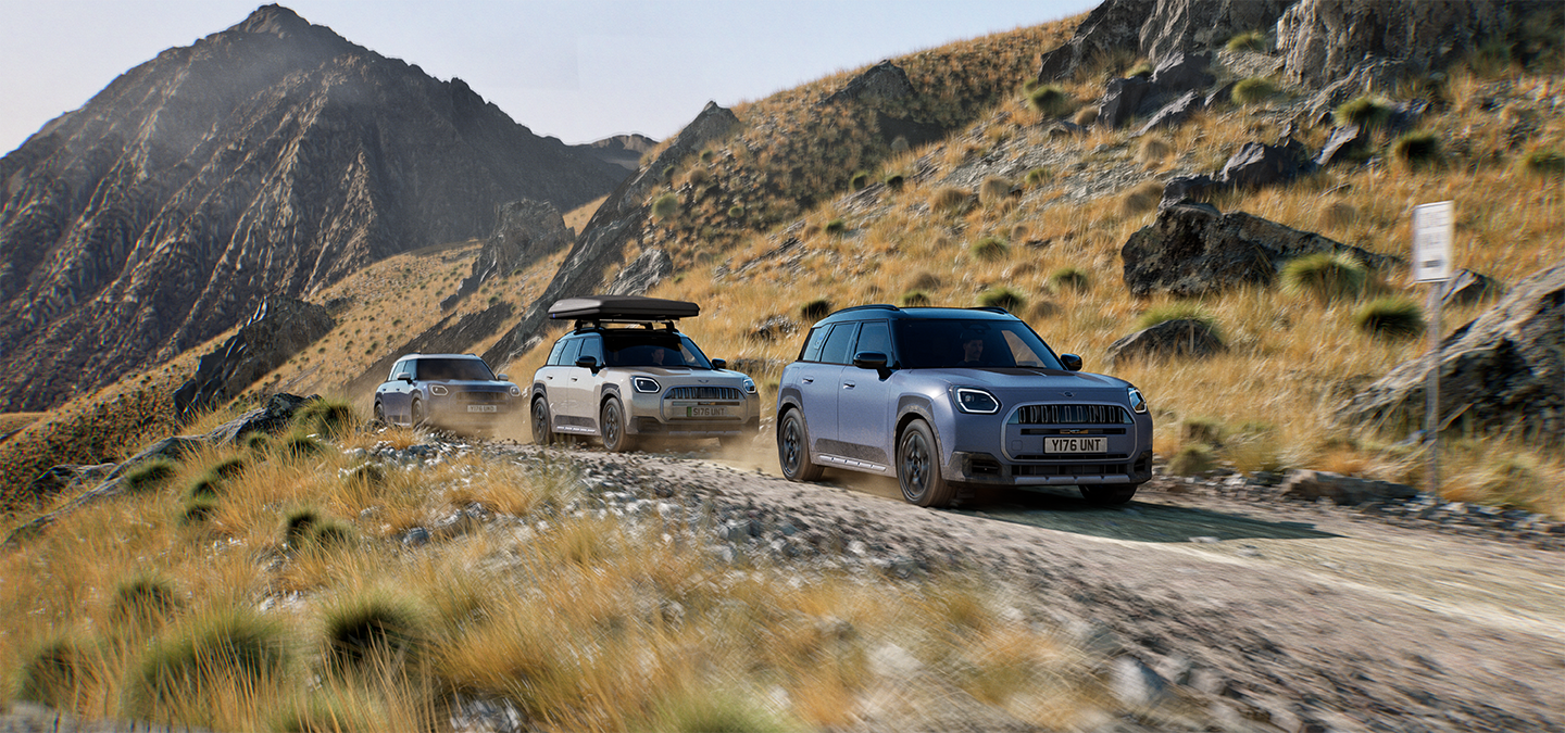 Immagine di più modelli MINI Countryman Untamed Edition che percorrono una strada di montagna fuoristrada.