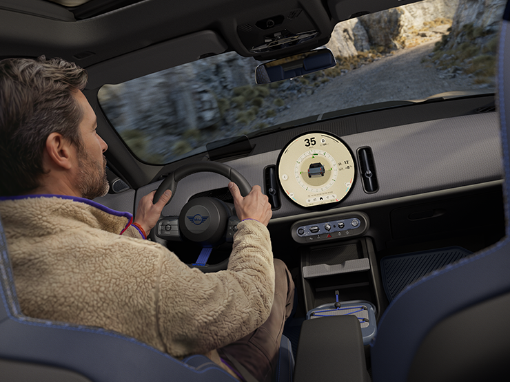Immagine di due persone alla guida della MINI Countryman Untamed Edition con Trail Mode attivato.