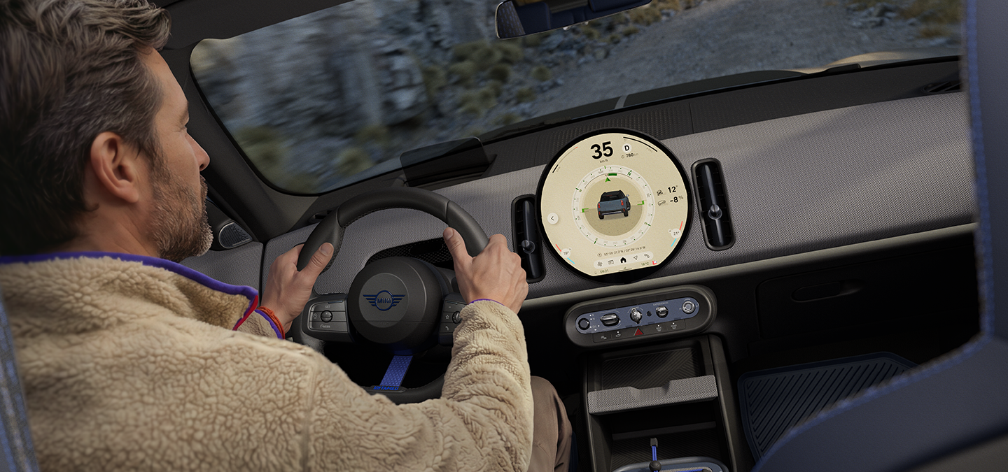 Immagine di due persone alla guida della MINI Countryman Untamed Edition con Trail Mode attivato.