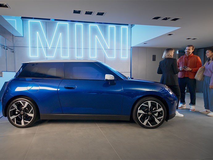 MINI Cooper elettrica vista da dietro e donna sorridente